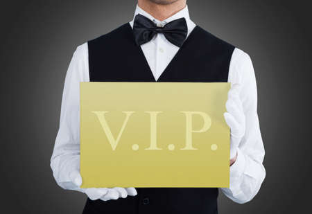 Close-up Of Waiter Showing Vip Text On Banner