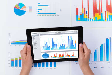 Close-up Of Person Analyzing Financial Graph Diagram On Digital Tabletの写真素材