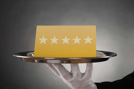 Close-up Of Waiter Serving Plate With Star Ratingの写真素材