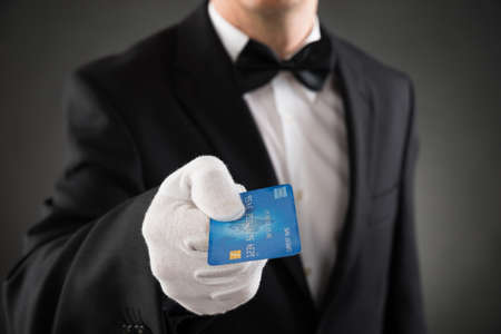 Close-up Of Waiter In Suit Giving Credit Cardの写真素材