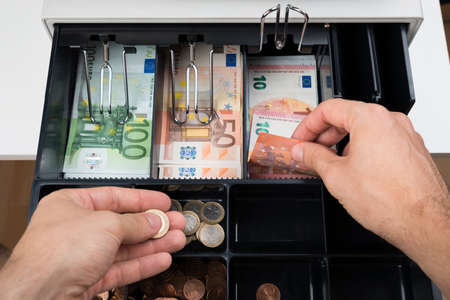 Close-up Of Person Hands With Money Over Cash Register