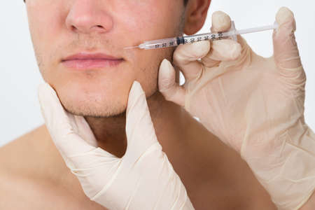 Close-up Young Man Getting Cosmetic Injection In His Faceの写真素材