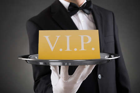 Close-up Of Waiter Showing Vip Text On Banner Close-up Of Waiter Showing Vip Text On Banner