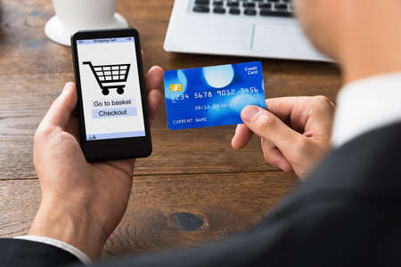 Close-up Of Businessperson Shopping Online With Mobile Phone And Credit Cardの写真素材