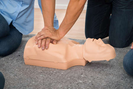 Close-up Of Person Practicing Cpr Chest Compression On Dummyの写真素材