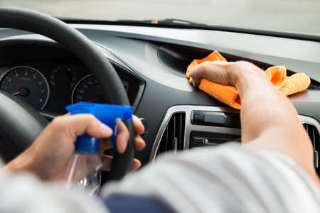Cropped image of mature male worker cleaning car dashboardの写真素材