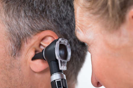 Close-up Of A Female Doctor Examining Patient's Ear With Otoscope