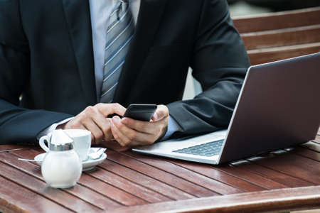 Close-up Of Man Sitting On Table Using Phone