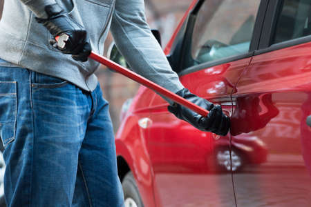 Close-up Of Thief Opening Car's Door With Crowbarの写真素材