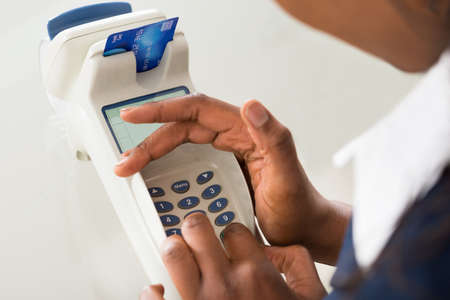 Close-up Of Person's Hand Using Credit Card Machine