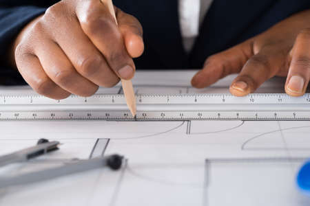 Close-up Of A Person's Hand Drawing Blue Print With Pencilの写真素材