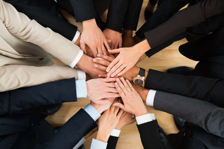 Directly above shot of business team stacking hands in office