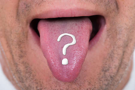 Closeup of man with question mark on tongue
