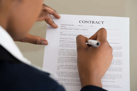 Close-up Of A Businesswoman Filling Contract Form