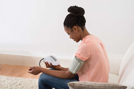 Young African Woman Checking Blood Pressure At Home