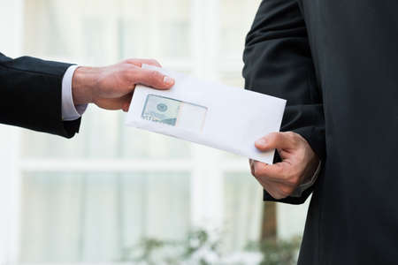 Cropped image of businessman receiving bribe from partner outdoors