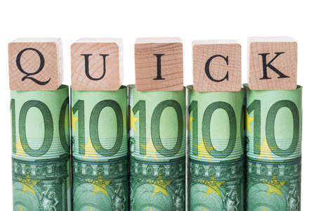 Quick blocks arranged on rolled euro notes against white background