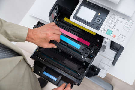Cropped image of businessman fixing cartridge in photocopy machine at office