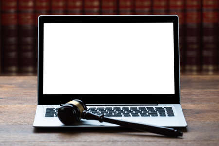Closeup of laptop and mallet on table in courtroom