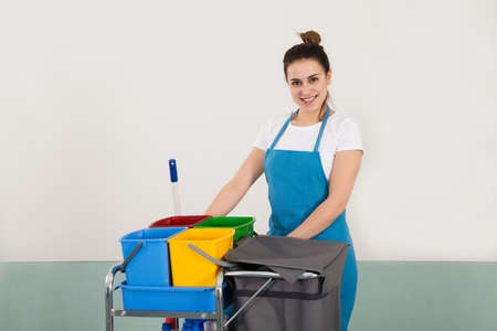 Portrait Of Happy Female Janitor With Cleaning Equipmentの写真素材