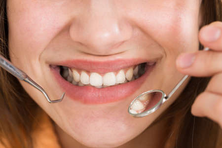 Close-up Of A Woman Examining Her Teethの写真素材