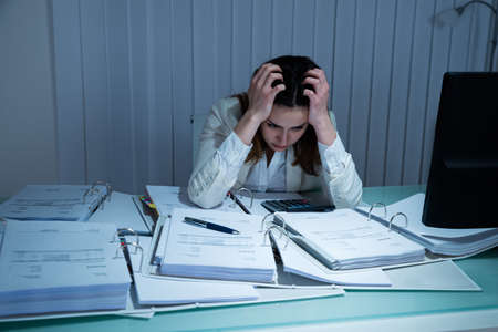 Stressed Young Businesswoman Working Late In Office
