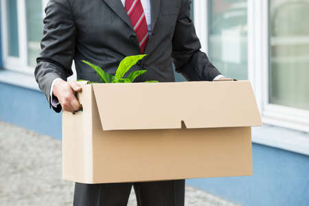 Close-up Of Unemployed Businessperson Carrying Cardboard Boxesの写真素材
