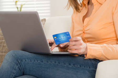 Close-up Of A Woman Using Card While Shopping On Laptopの写真素材