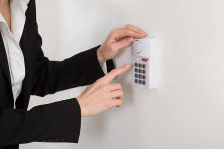 Close-up Of Woman Hand Pressing Button On Security Systemの写真素材