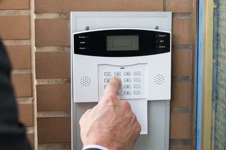 Close-up Of Businessperson Hand Entering Code In Security System