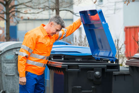 Working Man Looking In Dustbin On Streetの写真素材