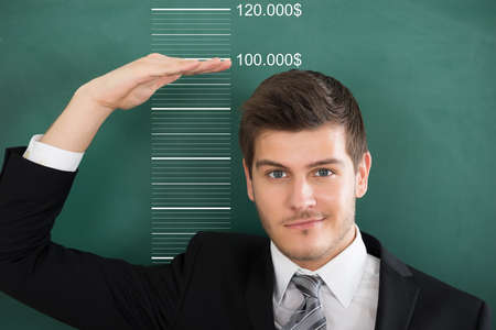 Rear View Of A Young Businessman Measuring Profitの写真素材