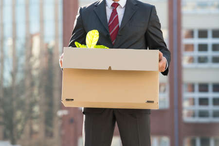 Close-up Of Businessperson Standing With Cardboard Box Outside Officeの写真素材