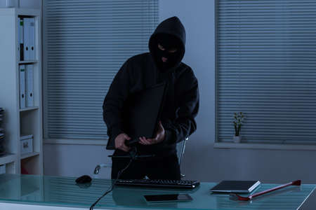 Thief Stealing Computer From Office At Night