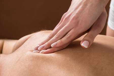 Close-up Of Young Man Receiving Back Massage At A Beauty Spaの写真素材