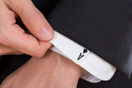 Close-up Of Businessman Hand Removing Ace Card From Sleeveの写真素材