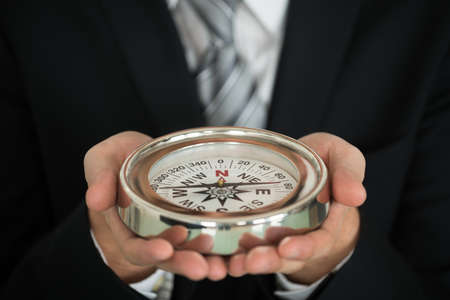 Close-up Photo Of Businessman Hand Holding Compassの写真素材