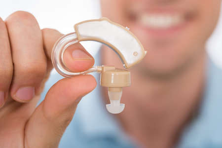 Close-up Of Man Hand Holding Hearing Aid
