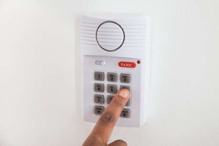 Close-up Of African Businesswoman Hand Pressing Button On Door Security System