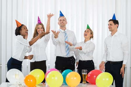 Group Of Businesspeople Standing Under Falling Confetti In Partyの写真素材