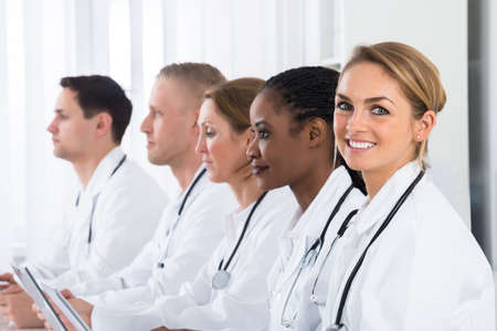 Happy Female Doctor Working With Her Colleagues In Hospital