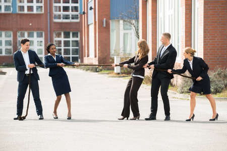 Happy Male And Female Businesspeople Playing Tug Of War