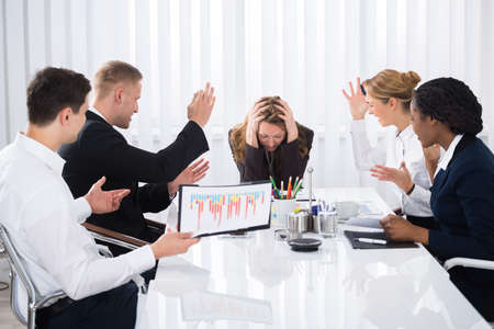 Upset Businesswoman Sitting With Aggressive Colleague In Meetingの写真素材