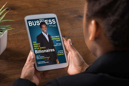 Close-up Of A Businesswoman Reading Online Magazine On Digital Tablet In Officeの写真素材