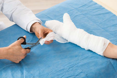 Close-up Of Doctor Bandaging Patient Hand In Hospitalの写真素材