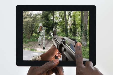 Close-up Of A Person Playing Game On His Digital Tablet Against White Backgroundの写真素材