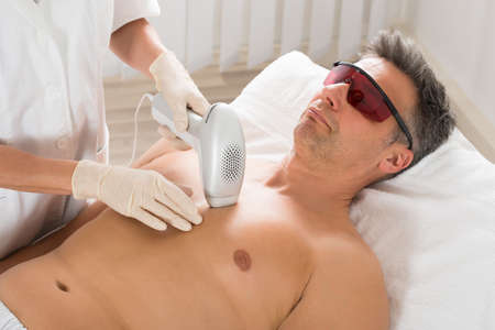 Beautician Giving Laser Epilation Treatment To Mature Man In Clinicの写真素材