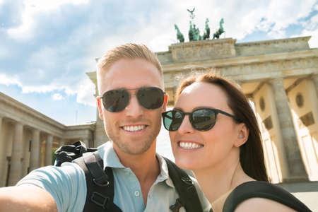 Close-up Of Young Happy Couple Taking Selfie In Front Of Brandenburg Gate In Germanyの写真素材