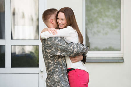 Young Happy Wife Welcoming Her Husband From Army Leaveの写真素材