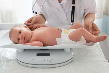 Close-up Of A Doctor Checking Weight Of Cute Little Baby